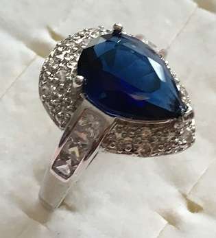 Elegant 15x10mm Blue Crystal Sapphire Surrounded bye White Diamond Impressions.(Size 9.5)